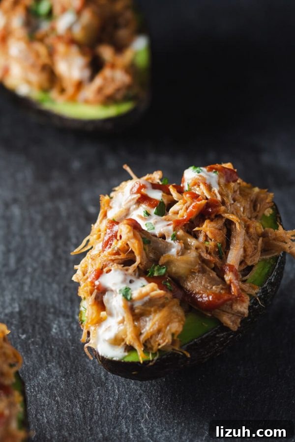 Keto Pulled Pork Stuffed Avocado Boats: Low-Carb Recipe 2 Pulled Pork Stuffed Avocado Boats are killer good! #stuffedavocados #avocadoboats #avocado #recipes #bbqpork #pulledpork #lowcarb #keto