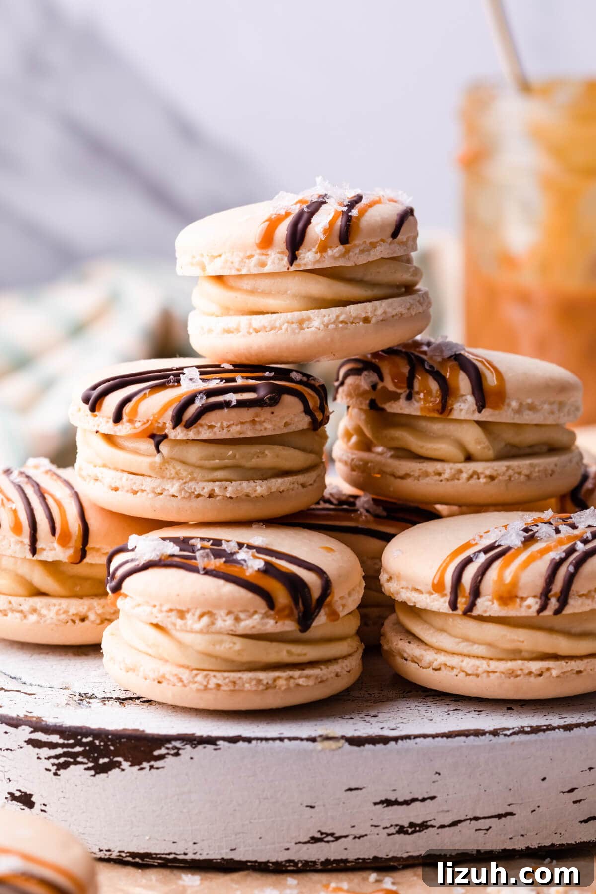 Irresistible Salted Caramel Macarons Recipe for Perfect Results 2 stack of macarons with salted caramel buttercream and drizzle of chocolate and caramel.