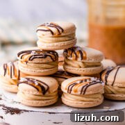 Irresistible Salted Caramel Macarons Recipe for Perfect Results 16 stack of salted caramel macarons on a white wooden board.
