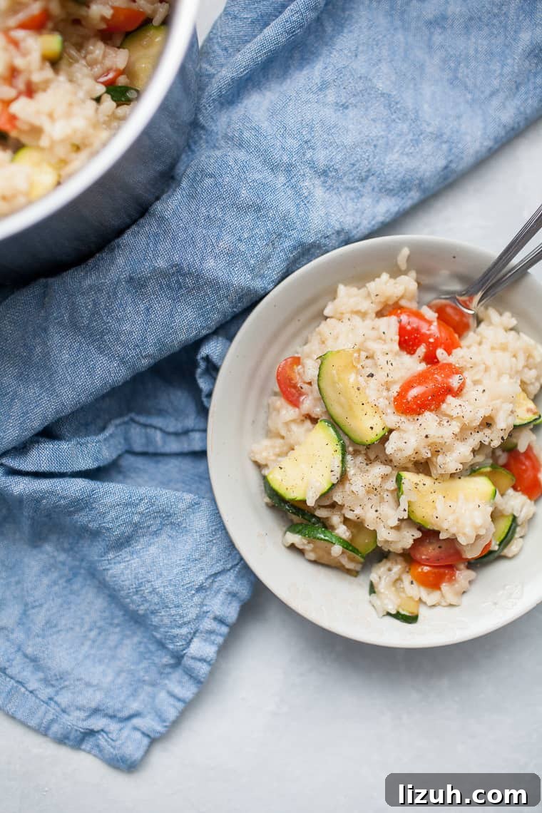 Gray bowl with vegetable risotto on top of a blue linen napkin.