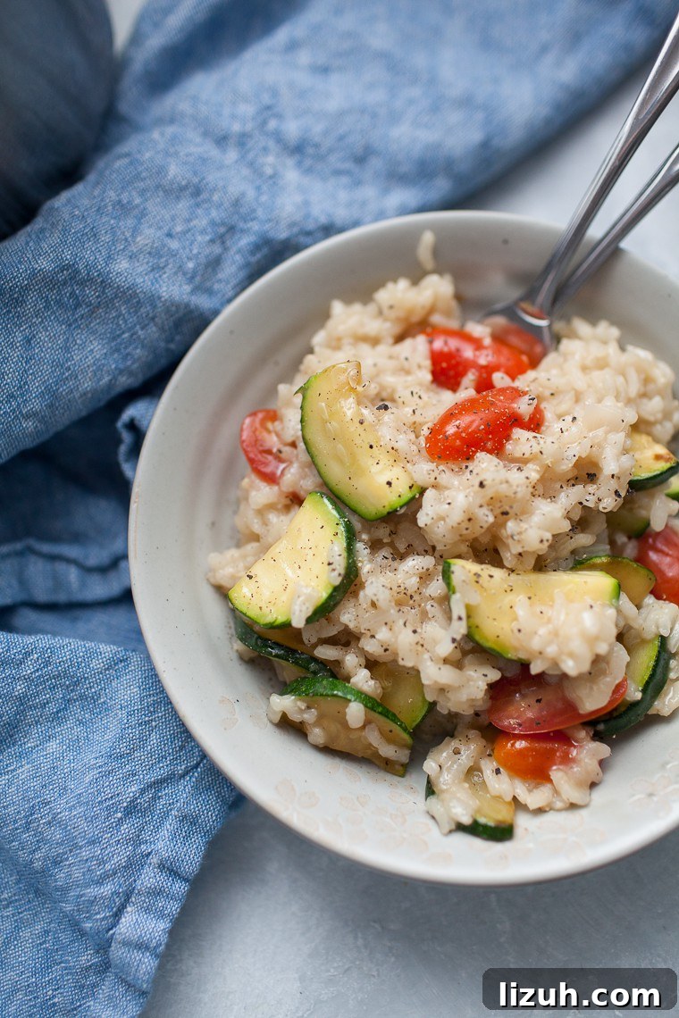 Gray bowl with vegetable risotto on top of a blue linen napkin.