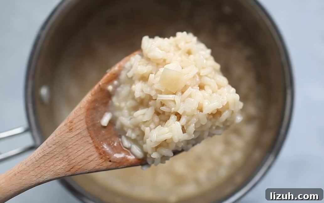 A wooden spoon full of risotto.