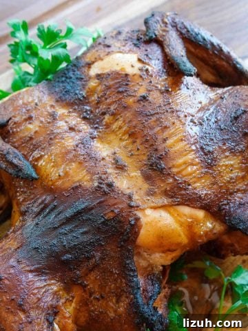 Cooked chicken on cutting board with green garnish