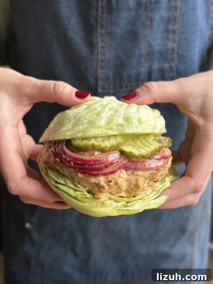 Quick Weeknight Ground Chicken Burgers Recipe 2 a photo of hands holding a ground chicken burger on a lettuce bun