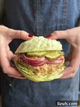 Quick Weeknight Ground Chicken Burgers Recipe 11 a photo of hands holding a ground chicken burger on a lettuce bun