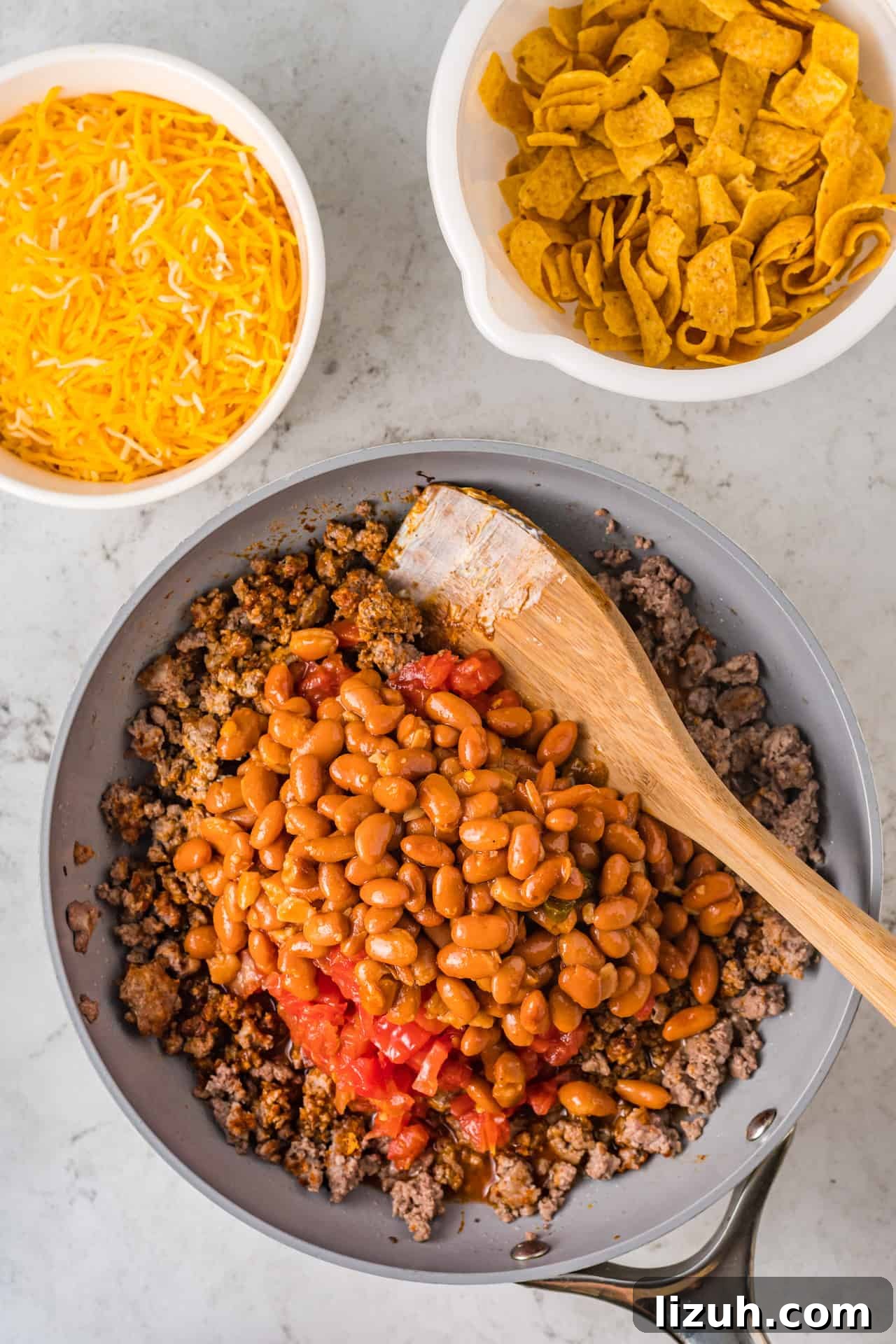 A season with taco meat, beans, tomatoes and cream cheese for a walking taco casserole.