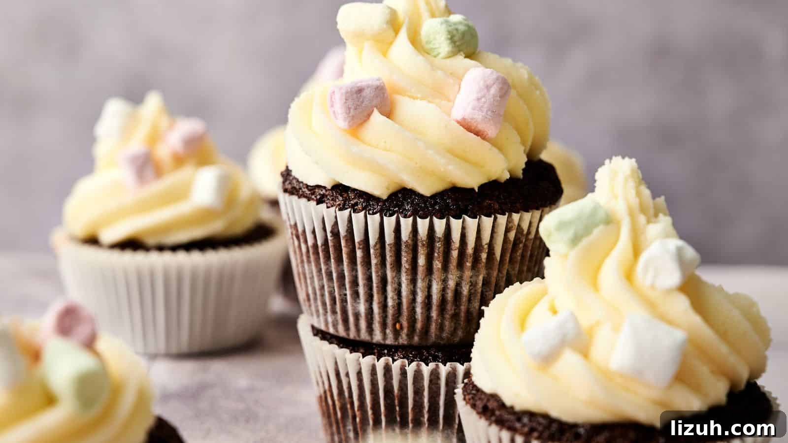 35 Game-Day Recipes to Win Your Season’s Food Lineup 17 Chocolate cupcakes with white frosting and small pastel-colored marshmallows on top, arranged in a group against a neutral background.