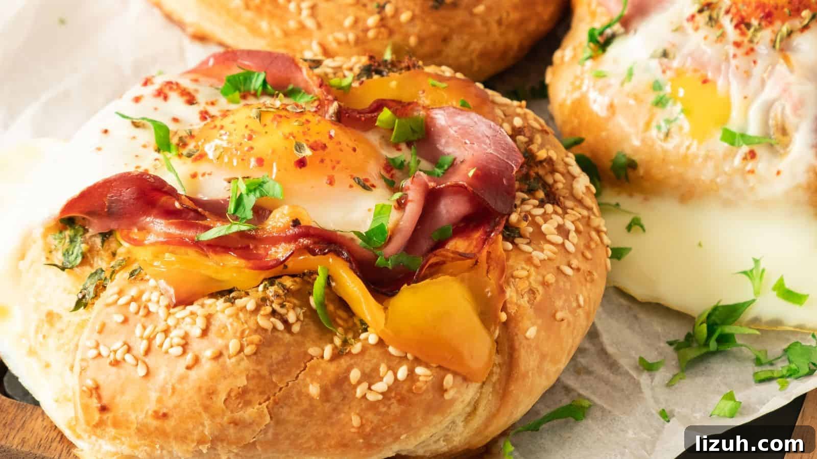 35 Game-Day Recipes to Win Your Season’s Food Lineup 20 Close-up of a savory pastry topped with a sunny-side-up egg, sliced ham, yellow bell pepper, and garnished with chopped parsley, served on a sesame seed bun.