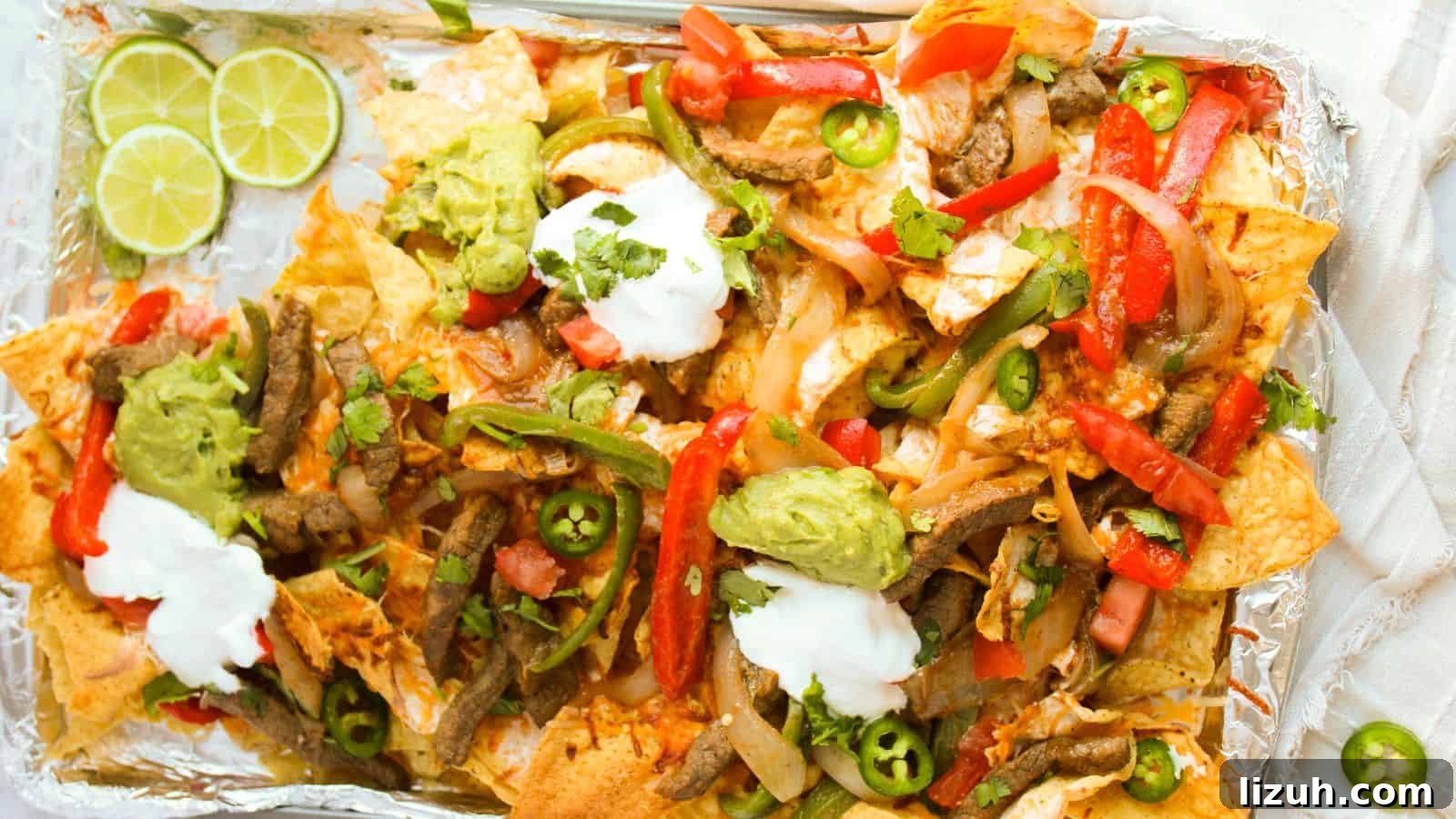 35 Game-Day Recipes to Win Your Season’s Food Lineup 25 A tray of loaded nachos topped with sliced beef, red and green peppers, jalapeños, guacamole, sour cream, and lime wedges on the side.