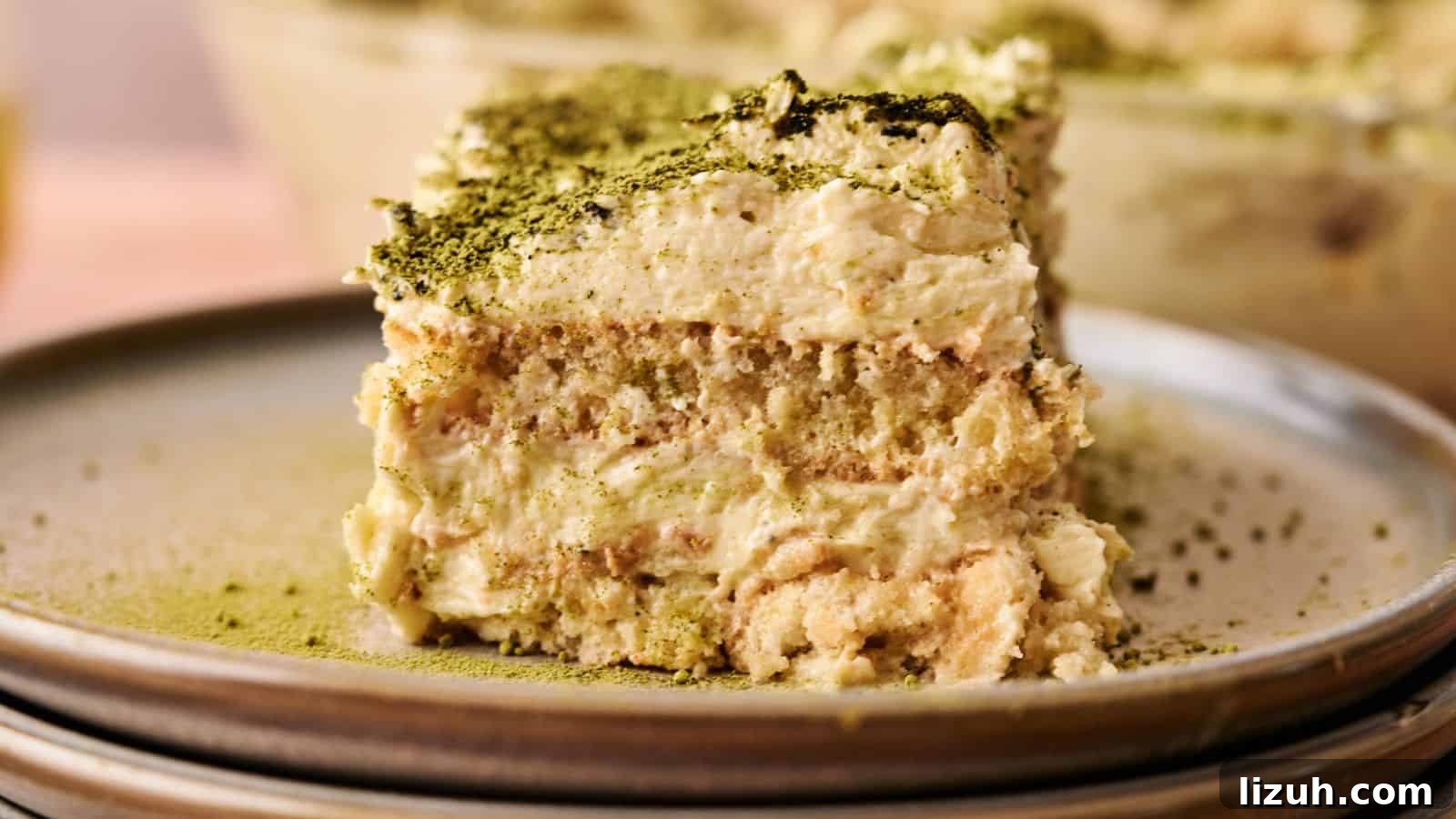 35 Game-Day Recipes to Win Your Season’s Food Lineup 29 A close-up of a slice of tiramisu topped with green matcha powder, served on a ceramic plate.