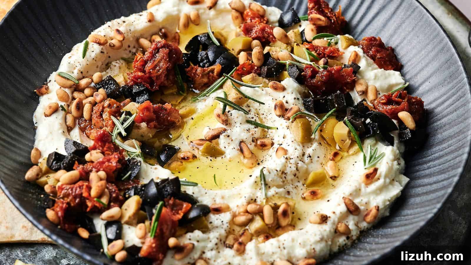35 Game-Day Recipes to Win Your Season’s Food Lineup 5 A bowl of creamy dip garnished with chopped black olives, sun-dried tomatoes, pine nuts, rosemary, olive oil, and black pepper.