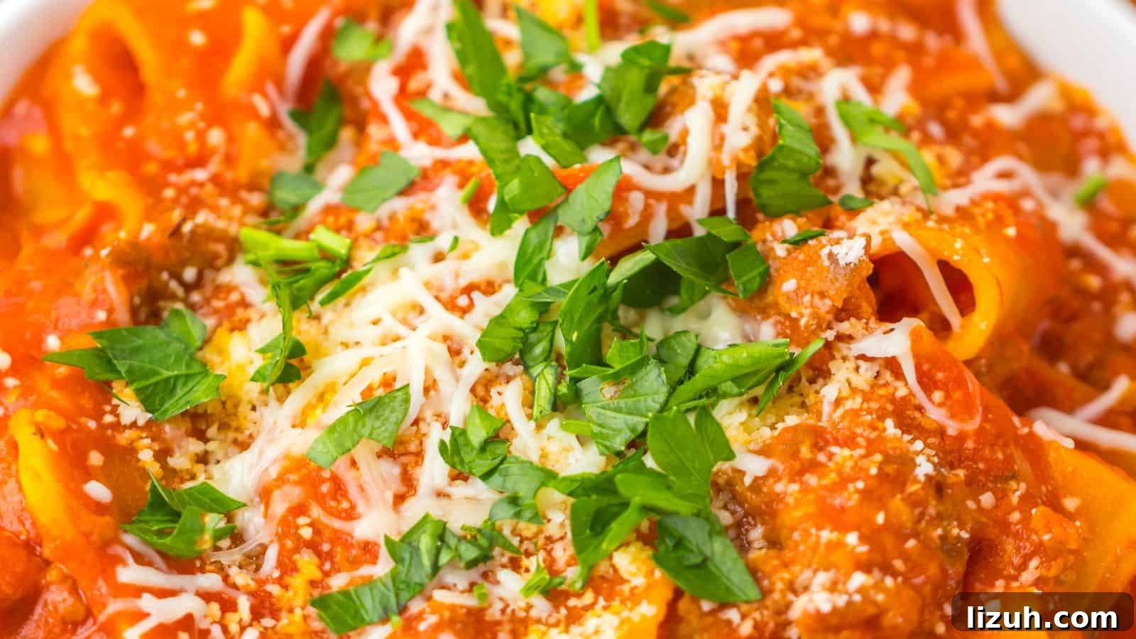 35 Game-Day Recipes to Win Your Season’s Food Lineup 6 Close-up of a plate of pasta topped with a red tomato-based sauce, grated cheese, and garnished with chopped parsley.