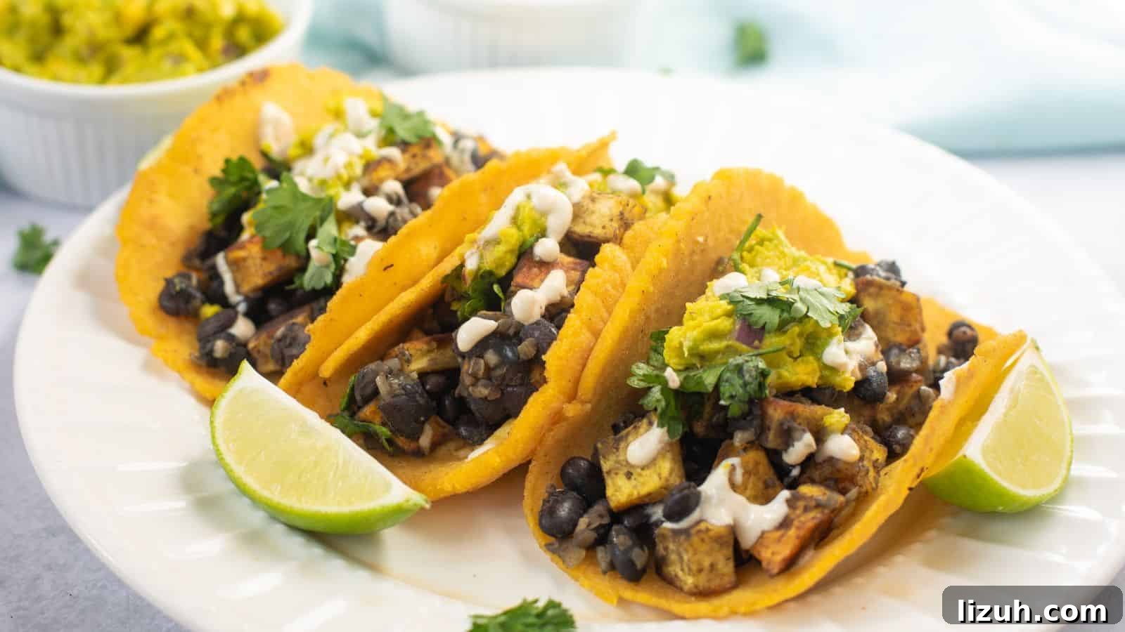 35 Game-Day Recipes to Win Your Season’s Food Lineup 8 Three tacos filled with black beans, tofu, and vegetables, topped with sauce and cilantro, served with lime wedges on a white plate.