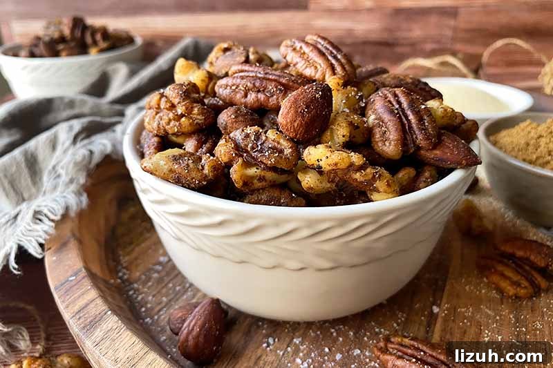 9 Delicious Tricks to Boost Flavor in Steamed Vegetables 4 Horizontal image of a white bowl filled with seasoned pecans, walnuts, and almonds on a wooden cutting board.