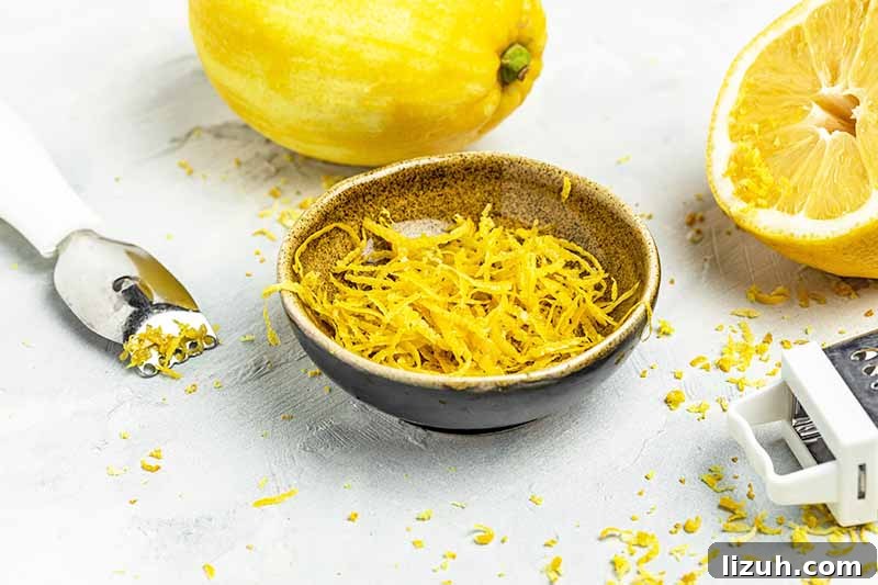 9 Delicious Tricks to Boost Flavor in Steamed Vegetables 7 Horizontal image of lemon zest in a bowl next to a whole lemon and a grater.