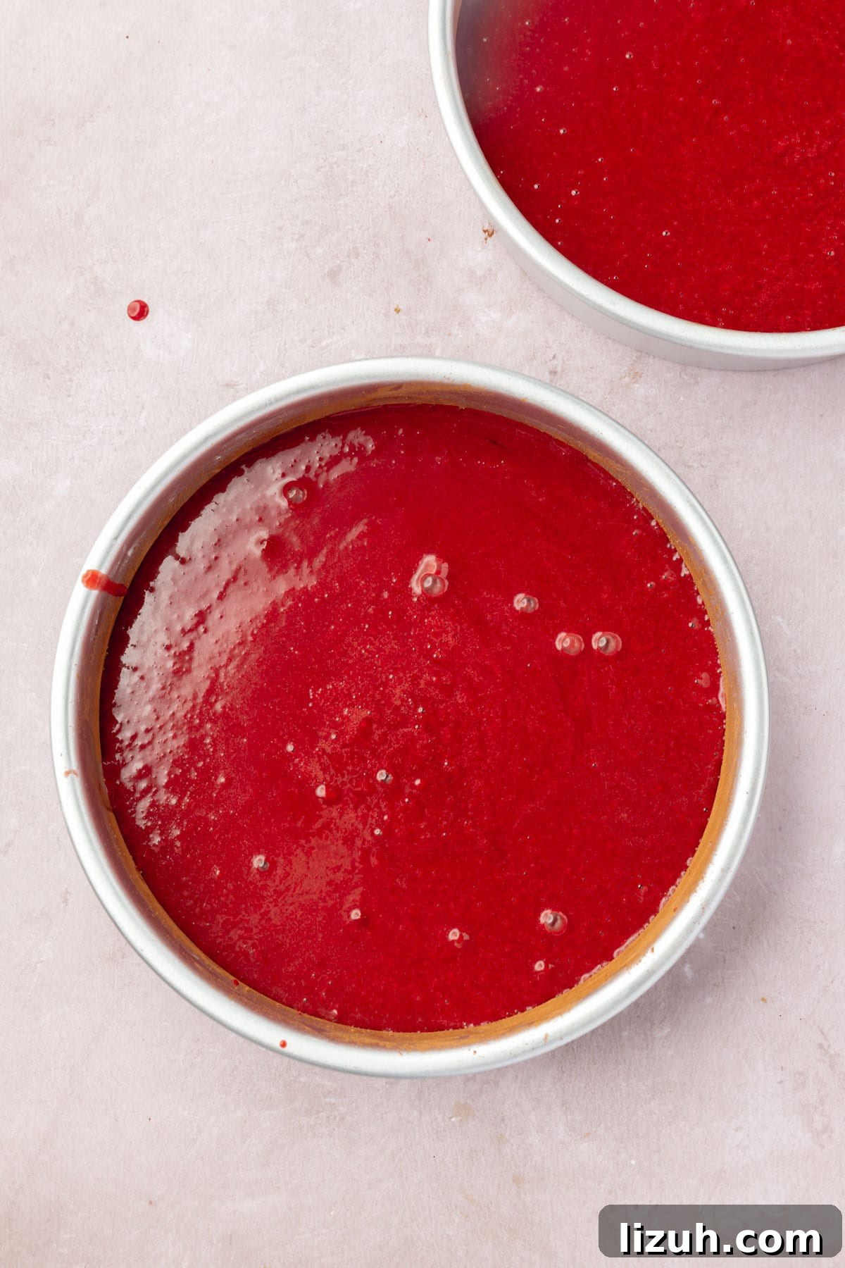 Gluten-Free Red Velvet Cake Recipe: Moist, Rich & Simple to Make 11 Two round cake pans filled with red velvet cake batter.