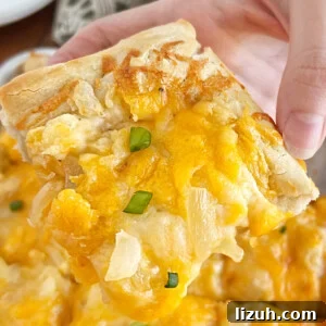 hand holding slice of pierogi pizza (pagach) with cheddar cheese and onions