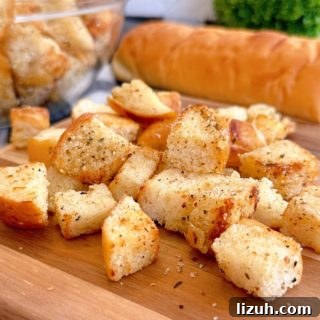 Easy Homemade Croutons on a wooden cutting board with a loaf of bread.