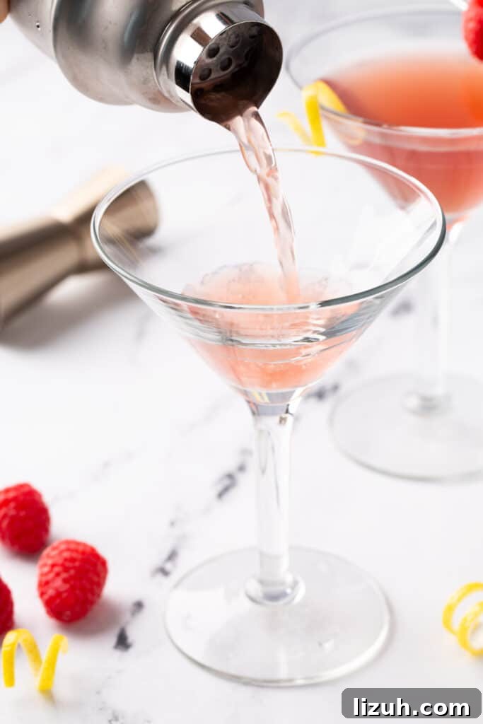 Martini being poured from a cocktail shaker into a glass.