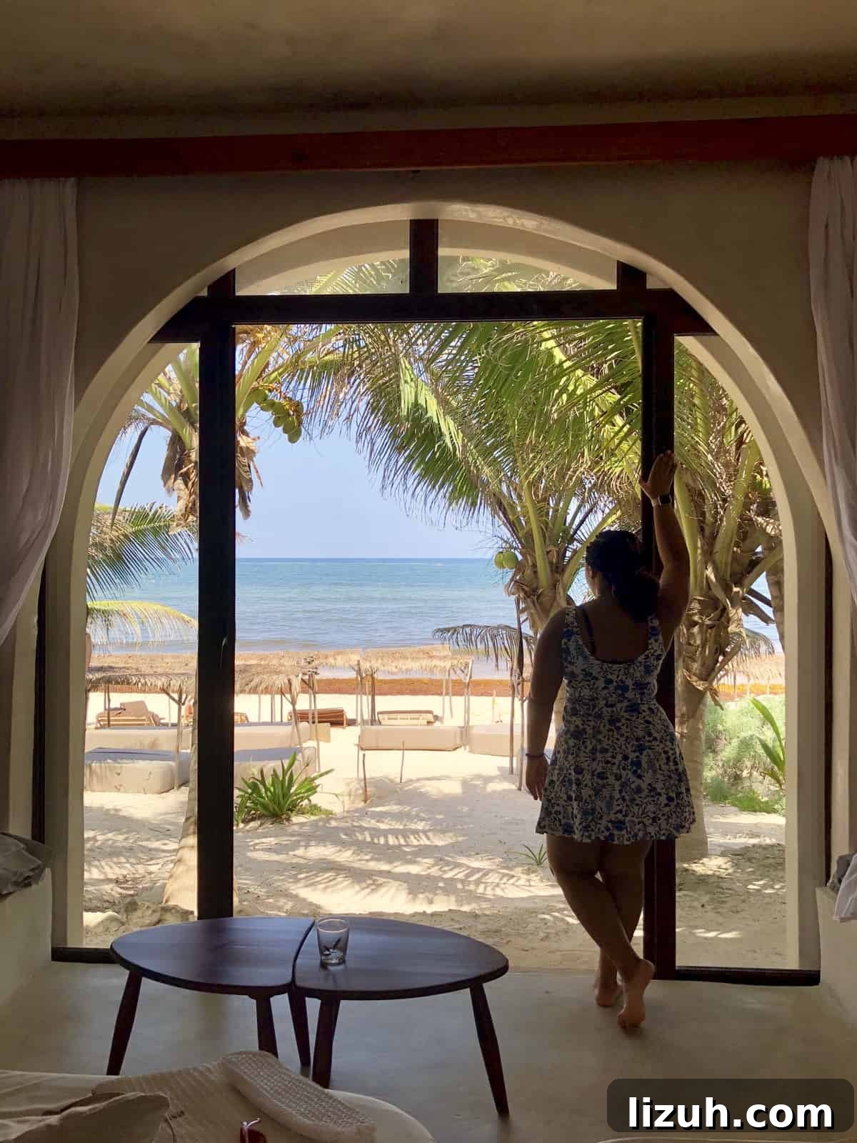 Tulum Travel Guide: Top Food, Where to Stay & Things to Do 6 Jessica looking out from hotel room onto a beach.