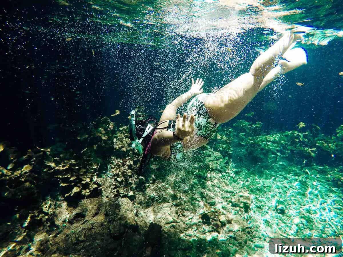 Tulum Travel Guide: Top Food, Where to Stay & Things to Do 7 Jessica swimming underwater, with a snorkel.