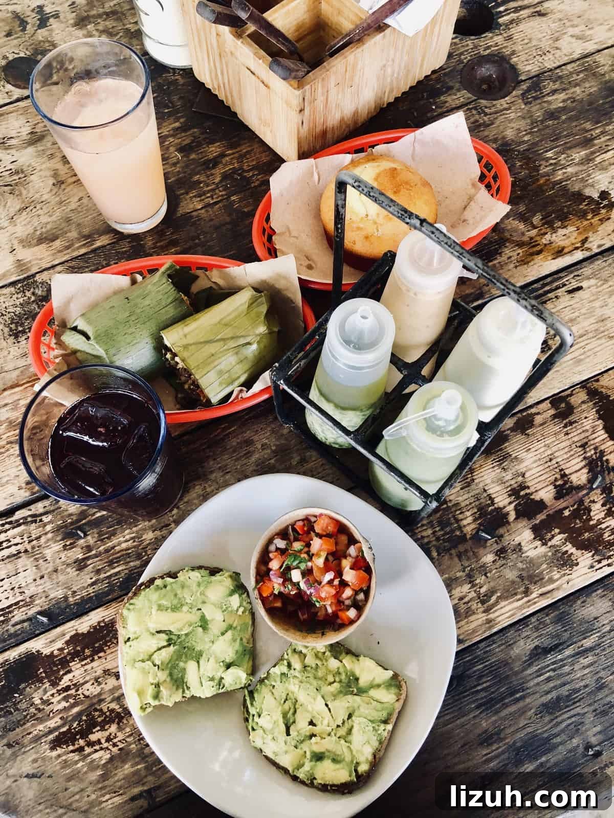 Tulum Travel Guide: Top Food, Where to Stay & Things to Do 10 Overhead view of plates and baskets of food on a wooden table.