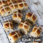 Fresh baked buns on a wire cooling rack.
