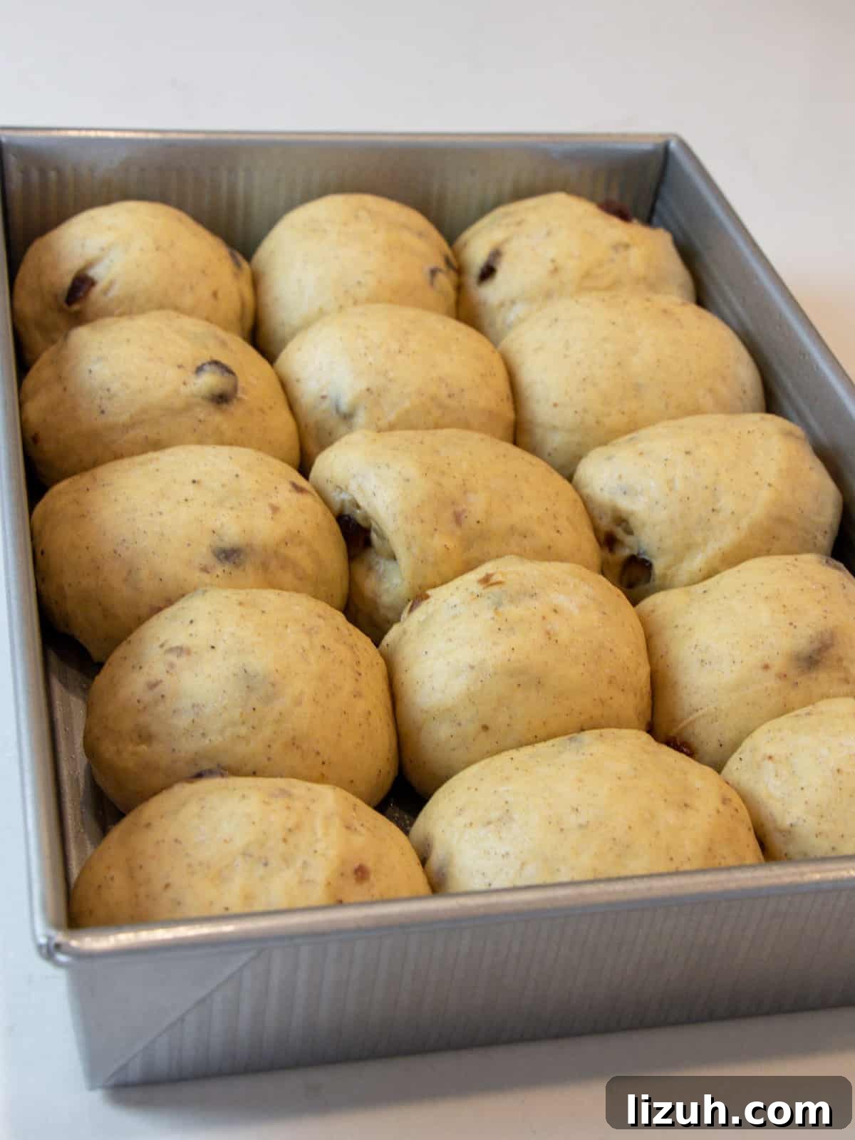 Risen rolls of dough in a baking dish.