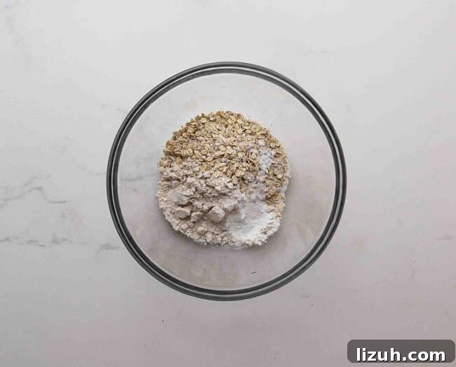Single-Serve Oatmeal Protein Pancakes: Quick High-Protein Recipe 4 Oats, oat flour, and baking powder in a bowl.