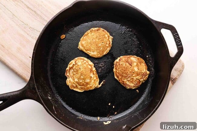 Single-Serve Oatmeal Protein Pancakes: Quick High-Protein Recipe 7 Pancakes on a cast iron skillet.