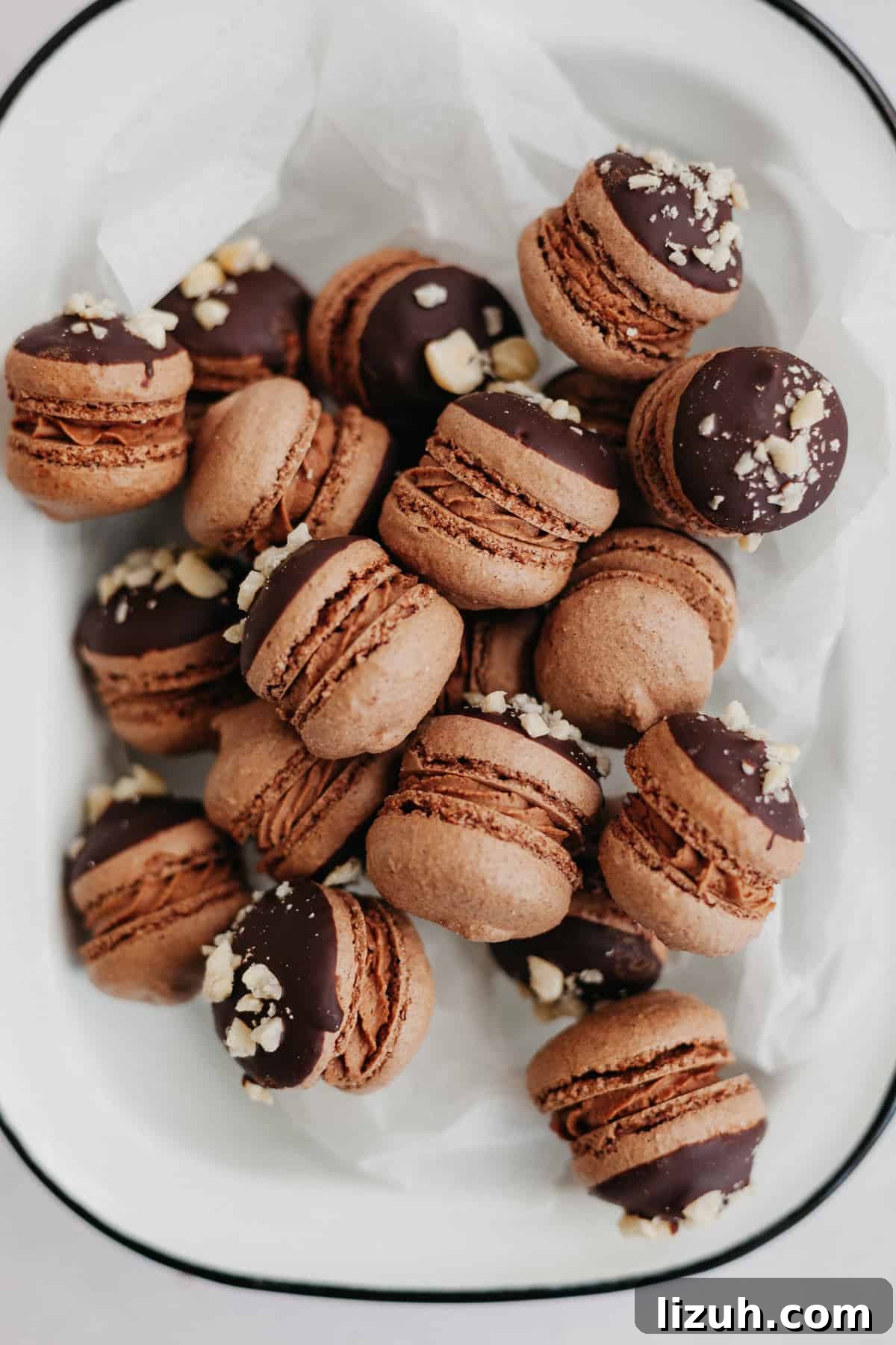 Nutella-Filled Chocolate Macarons: Classic French Cookie Recipe 2 Nutella macarons on parchment paper