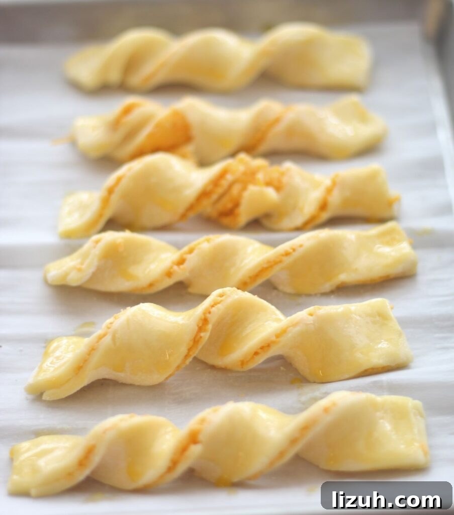 Crispy Gluten-Free Cheese Straws Made with Puff Pastry 3 cheese straws placed on baking sheet