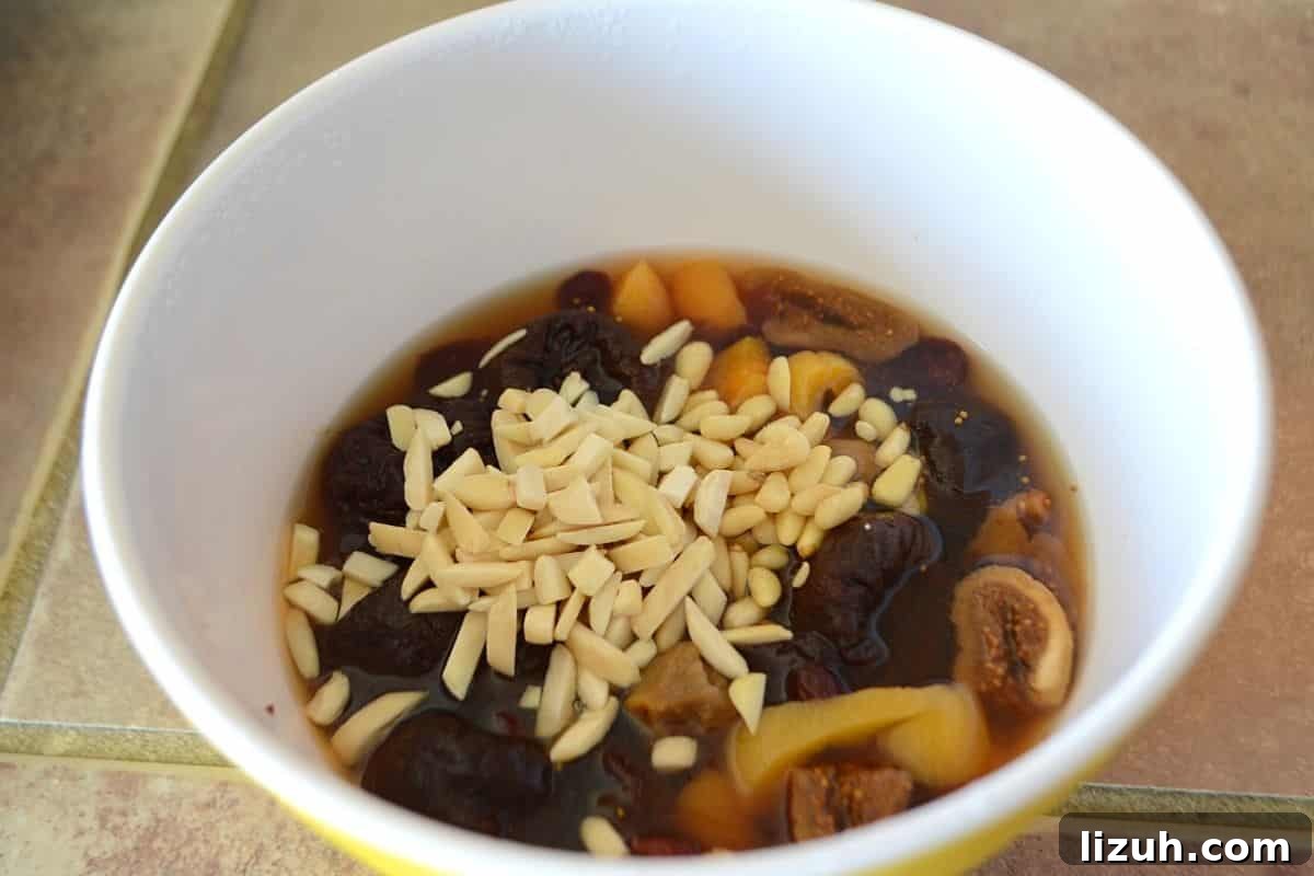 Khoshaf: How to Make Traditional Middle Eastern Dried Fruit Compote 5 Dried fruits soaked in flavored water with nuts in a deep bowl.