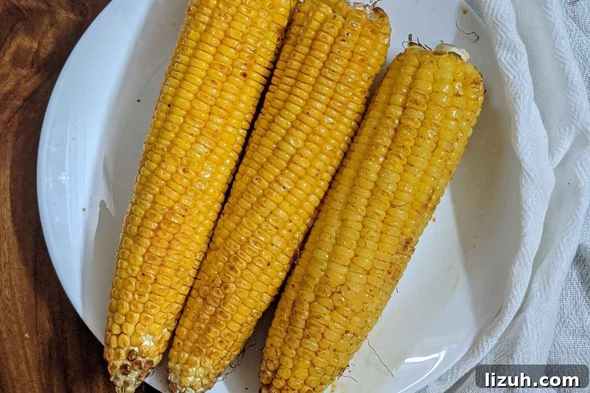 3 corn on the cob on a plate.