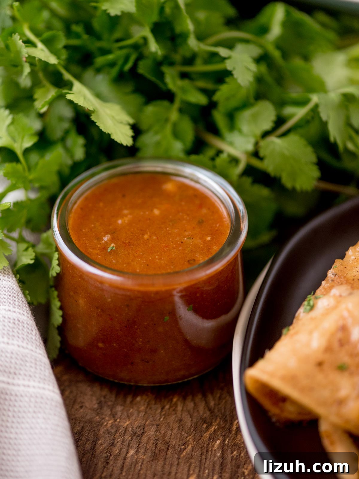 Authentic Homemade Enchilada Sauce Recipe for Rich Flavor 6 Enchilada sauce in a jar with cilantro bunch in the background