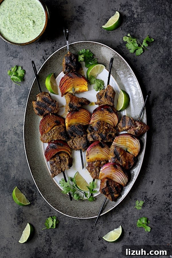 Indian Beef Kabobs with Cilantro Coconut Sauce recipe 8 Indian-Style Beef Kabobs with Cilantro-Coconut Sauce - Another overhead shot of kabobs on gray-rimmed platter garnished with cilantro and lime wedges