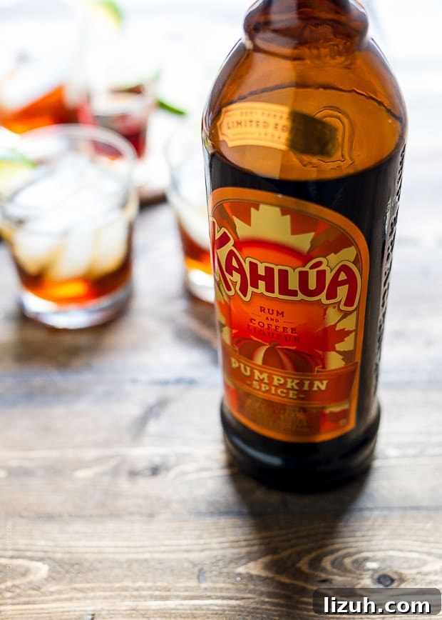 Pumpkin Spice Dark and Stormy Cocktail Recipe 5 A bottle of Kahlua Pumpkin Spice on a wooden surface.