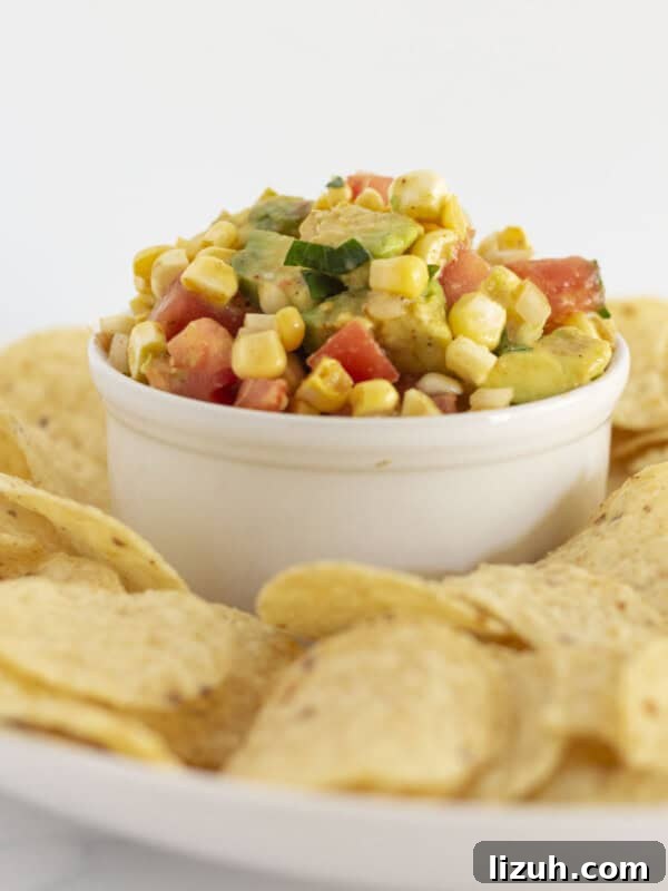 Pepperoni Pizza Cheese Ball Game-Day Appetizer 10 Corn and avocado salsa served in a white bowl with corn chips.