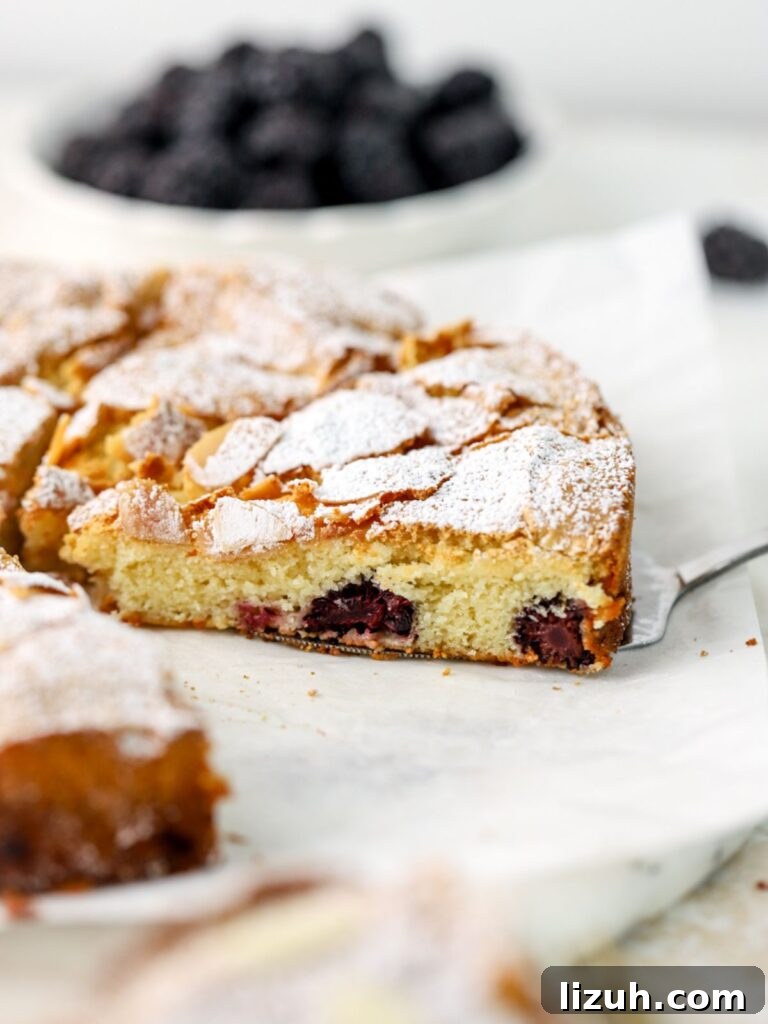 Moist Blackberry Almond Cake Recipe with Crisp Almond Topping 10 Blackberry cake cut into slices on a white platter.