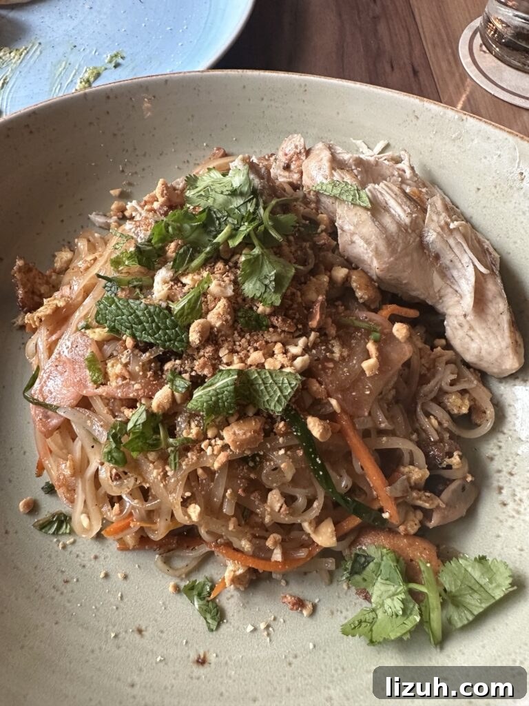 Asian style noodles with meat, peanuts, carrots, onion, and basil