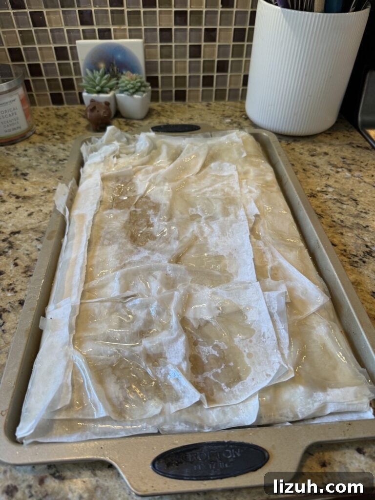 The Phyllo dough folded over the meat mixture in a baking dish on the kitchen counter