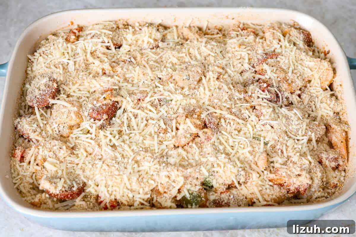 Overhead shot of casserole ingredients in a baking dish with breadcrumb topping sprinkled over the top. 