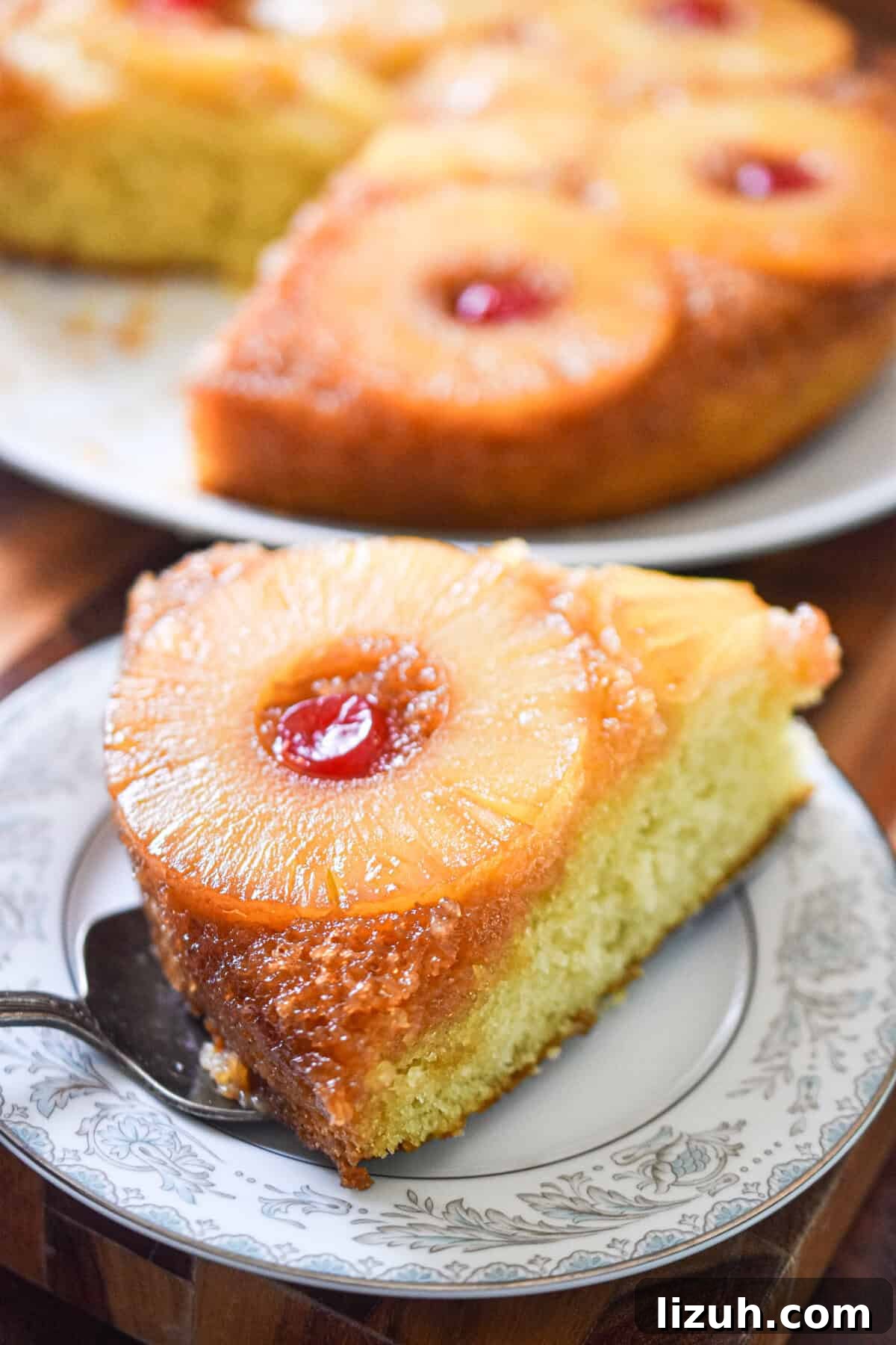 Sourdough Pineapple Upside-Down Cake Recipe for Moist, Tangy Loaf 2 A piece of the sourdough pineapple upside down cake is on a plate with the rest of the cake behind it.