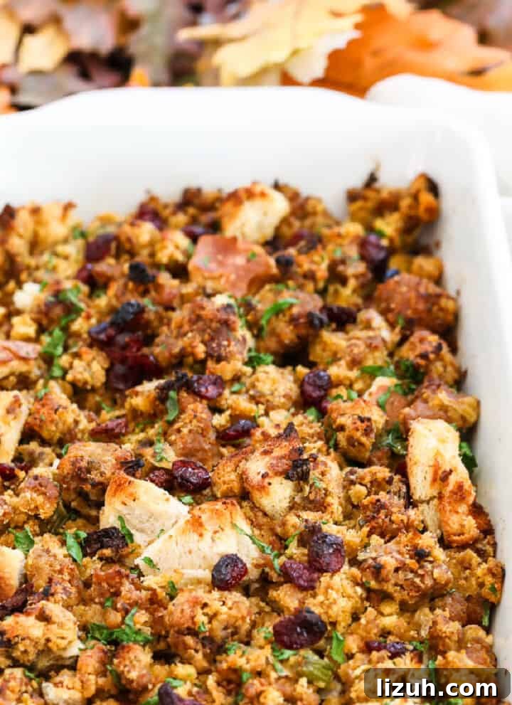 A white casserole dish filled with Sausage Stuffing baked to a golden brown.