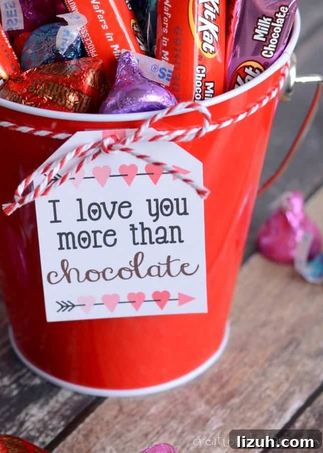 Valentines gift basket filled with chocolate. I love you more than chocolate valentine gift tag attached to bucket of chocolate