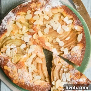 Italian pear almond cake on a plate with a slice cut out.