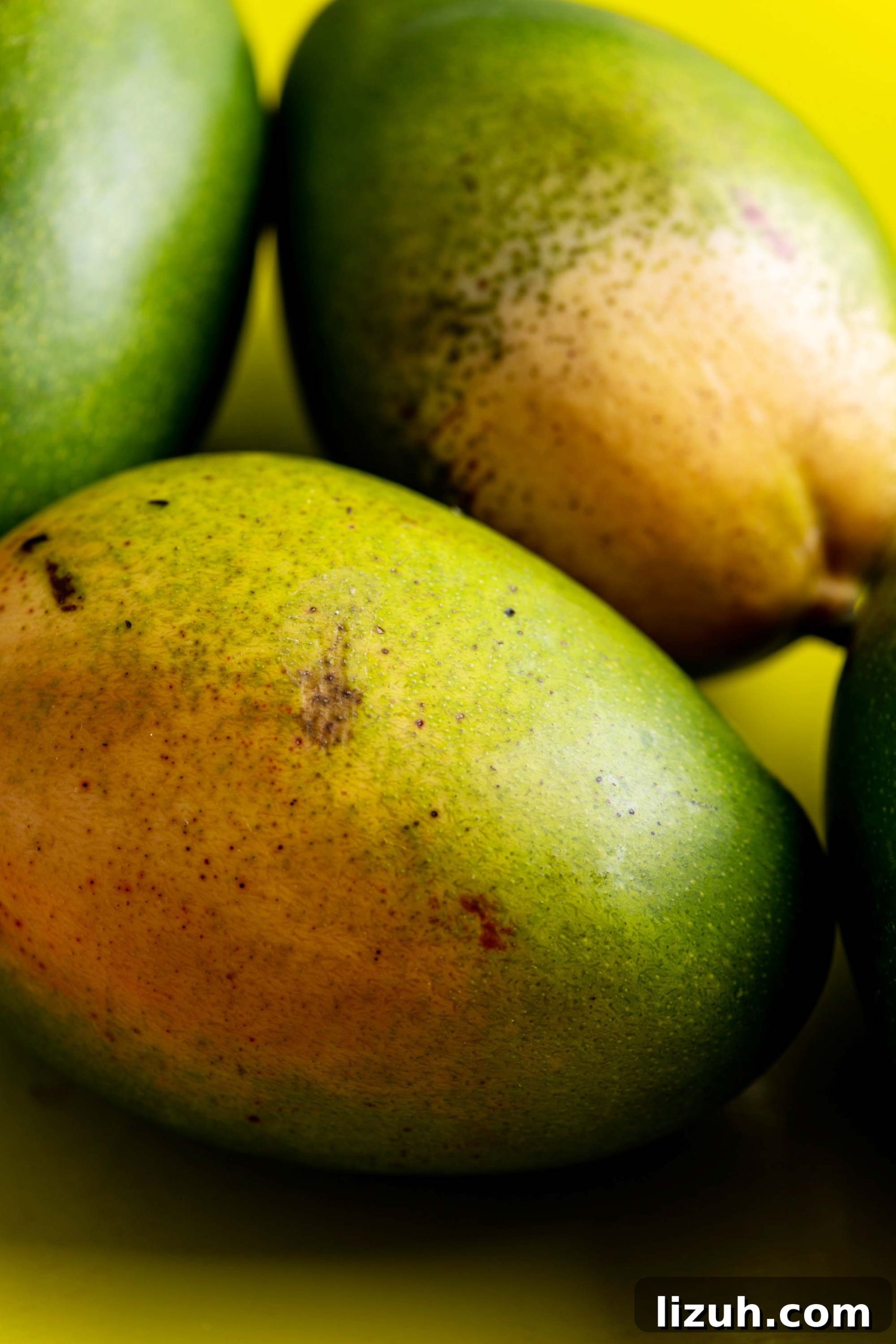 How to Cut a Mango Like a Pro: Quick Step-by-Step Guide 2 Pile of mangos on a yellow surface.