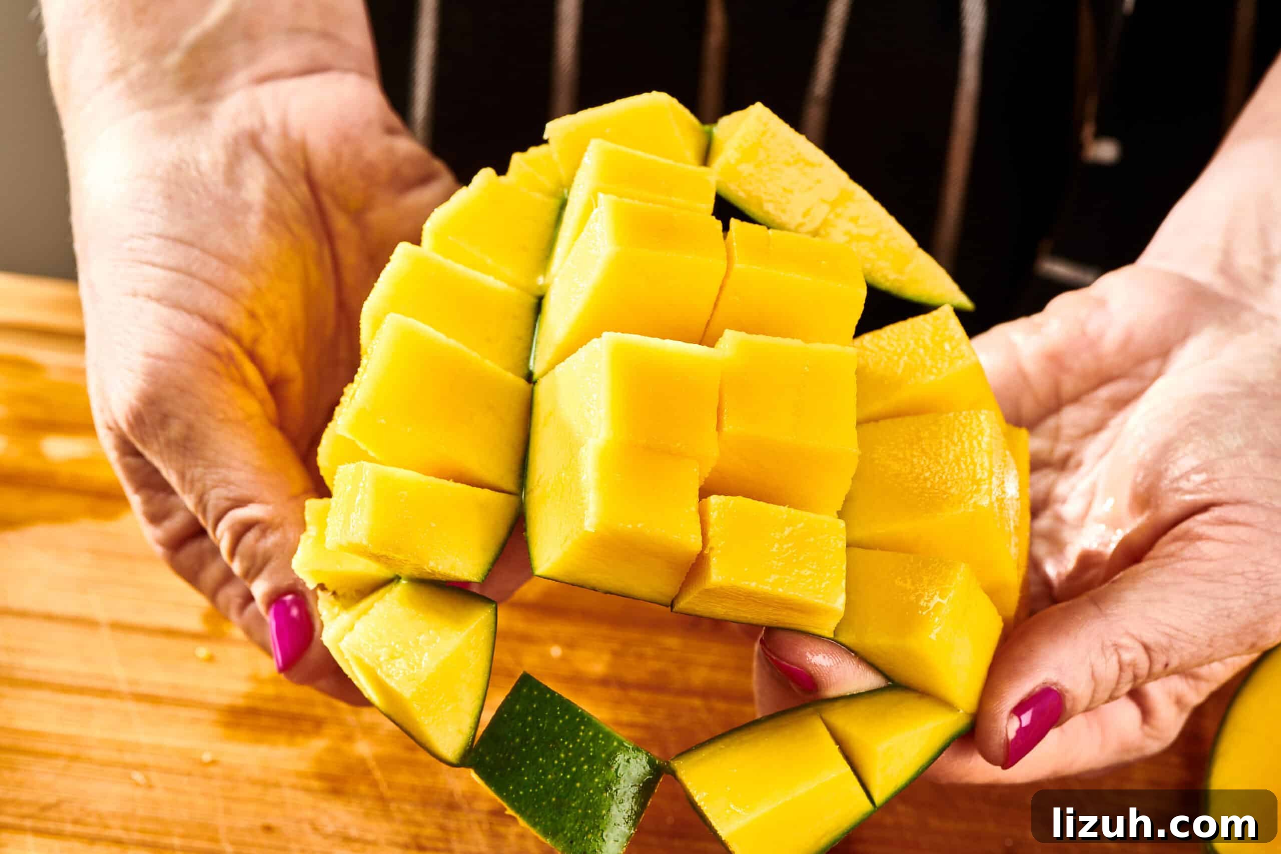 How to Cut a Mango Like a Pro: Quick Step-by-Step Guide 10 Woman holding scored mango to show cubes.