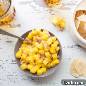 Table set with chips and a bowl of Citrusy Mango Ginger Salsa.