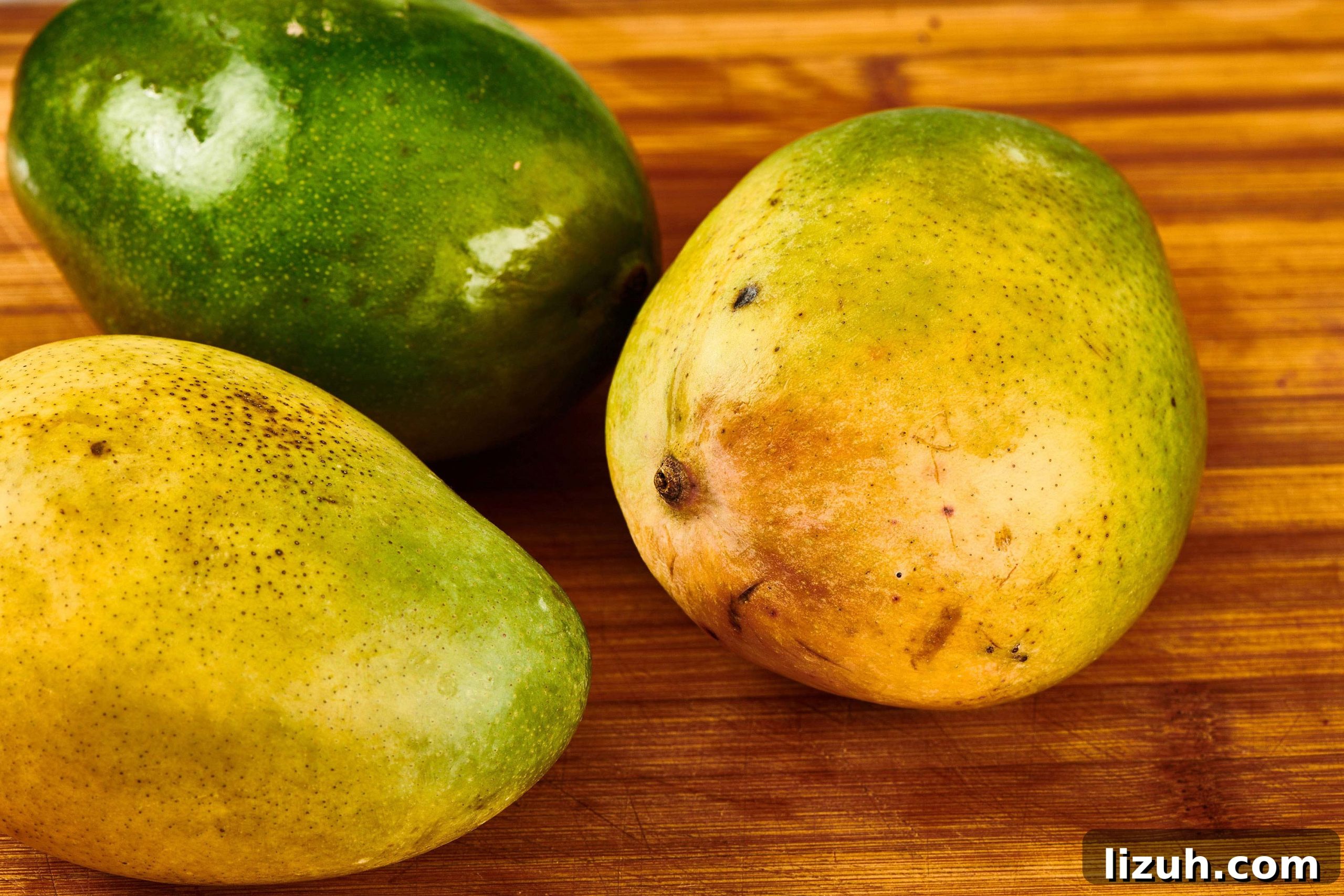 How to Cut a Mango Like a Pro: Quick Step-by-Step Guide 3 Mangos on a wooden cutting board.
